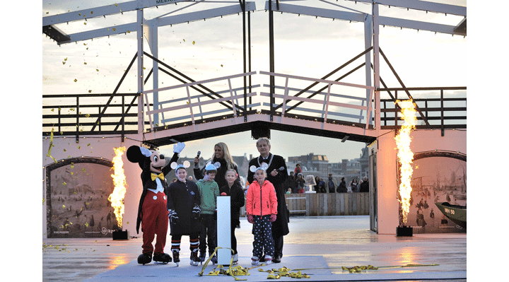 Schaatsende Mickey Mouse als eerste op het ijs van Ice Amsterdam na opening door burgemeester Van der Laan